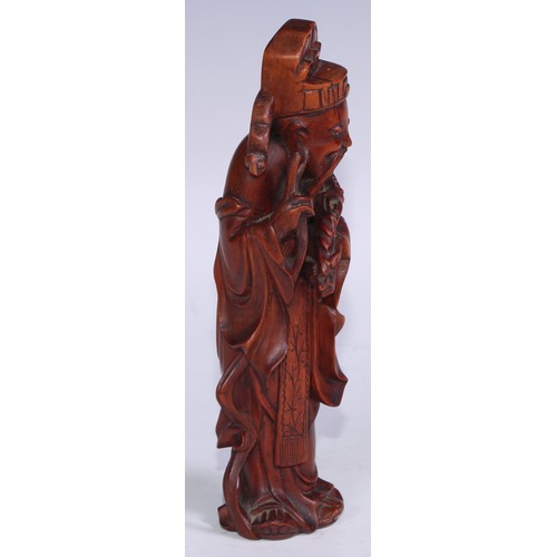 905 - A Chinese boxwood figure, carved as an Immortal, he stands, holding a ruyi sceptre, 21cm high, 19th/... 