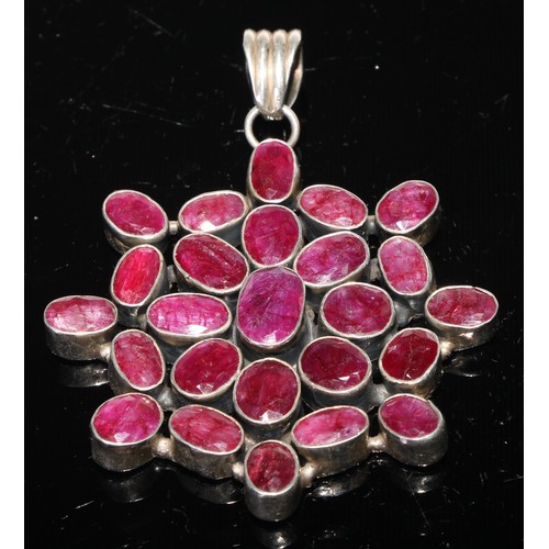 424 - A large ruby pendant, the twenty five oval stones set in white metal, 8.5cm over loop