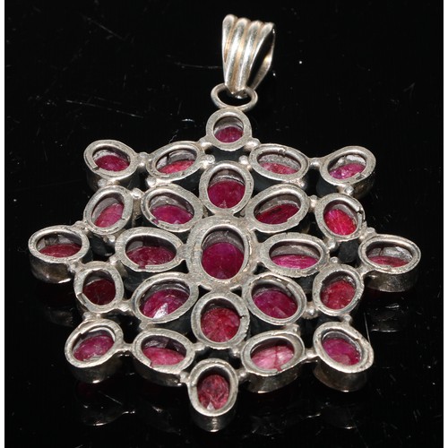 424 - A large ruby pendant, the twenty five oval stones set in white metal, 8.5cm over loop