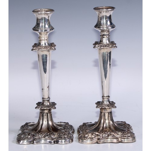 27 - A pair of George/William IV Old Sheffield Plate table candlesticks, waisted campana sconces, flower ... 