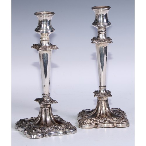 27 - A pair of George/William IV Old Sheffield Plate table candlesticks, waisted campana sconces, flower ... 