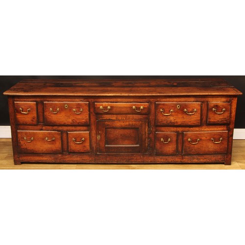 1614 - A George III vernacular oak low dresser, plank rectangular top above an arrangement of drawers and a... 