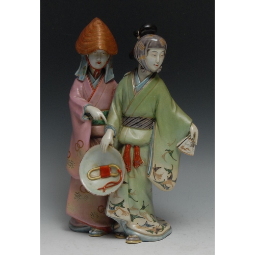 998 - A Japanese figure group, of two ladies, in flowing robes, one holding a bowl, 30cm high, on stand