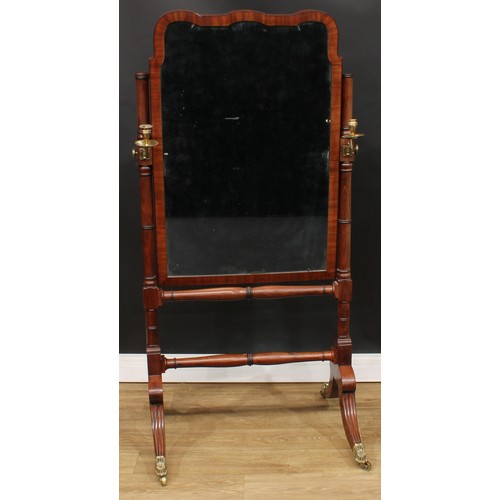 1771 - A Regency Revival mahogany cheval mirror, bevelled plate flanked by brass candlestick holders, turne... 