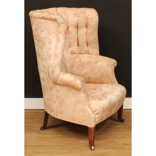 1612 - A George III Revival wingback armchair, stuffed-over upholstery, tapered square forelegs, brass cast... 