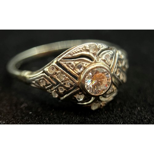 445 - An Edwardian diamond pave set ring, the central stone within a bright cut and diamond set tablet, Si... 