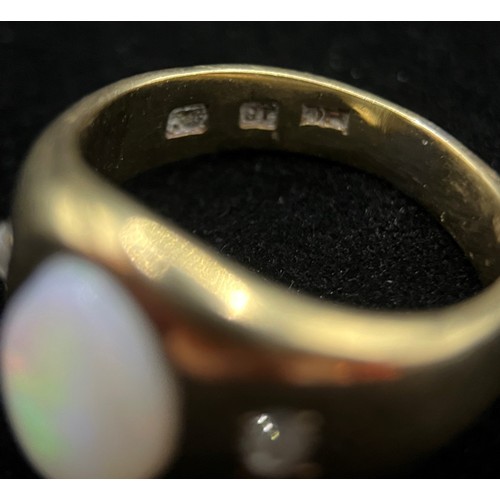 423 - A Victorian 18ct gold three stone opal and diamond ring, the central oval cabochon stone flanked by ... 