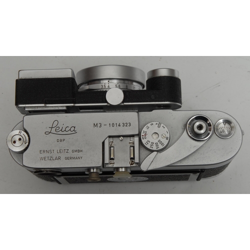 1755 - A Leica M3 camera, with wide angle and long lenses, serial no.1014323, brown leather case; an associ... 