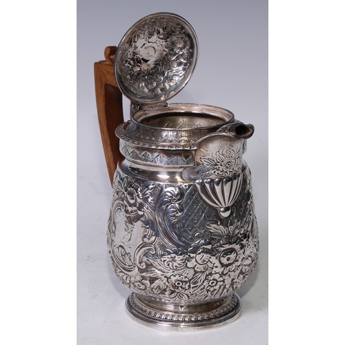 152 - A George III silver water jug, later chased with flowers, scrolling foliage and panels of trellis, 1... 