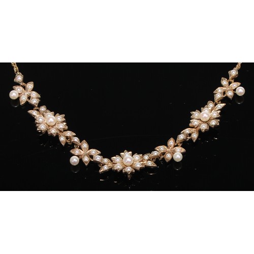 418 - A 9ct gold necklet as a garland of flowerheads, each set with an arrangement of graduated seed pearl... 