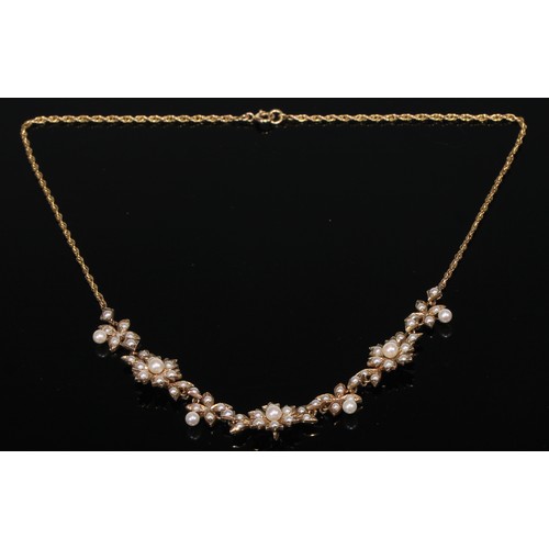 418 - A 9ct gold necklet as a garland of flowerheads, each set with an arrangement of graduated seed pearl... 