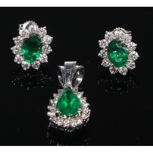 412 - A 14k white gold emerald and diamond pendant with a pair of earrings ensuite, 6.9g