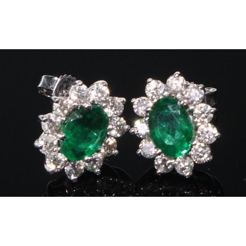 412 - A 14k white gold emerald and diamond pendant with a pair of earrings ensuite, 6.9g