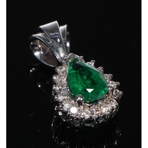 412 - A 14k white gold emerald and diamond pendant with a pair of earrings ensuite, 6.9g