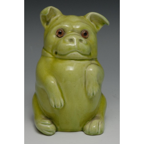 517 - A Burmantofts Faience model of a seated dog, resting on his back legs, glazed throughout in olive gr... 