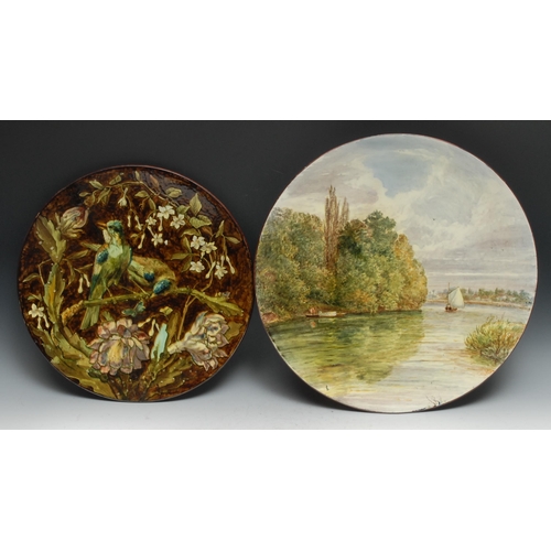 478 - A Doulton Lambeth Aesthetic Movement circular charger, painted impasto with birds on a blossoming br... 