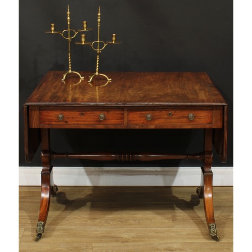 1767 - A Regency mahogany sofa table, rounded rectangular top with reeded edge and fall leaves above a pair... 