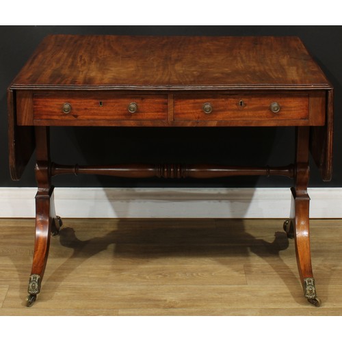 1767 - A Regency mahogany sofa table, rounded rectangular top with reeded edge and fall leaves above a pair... 