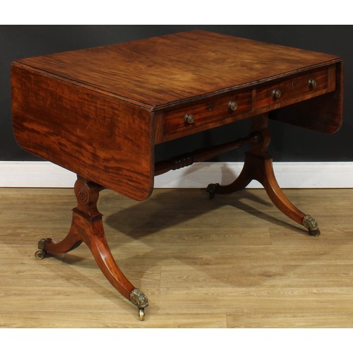 1767 - A Regency mahogany sofa table, rounded rectangular top with reeded edge and fall leaves above a pair... 