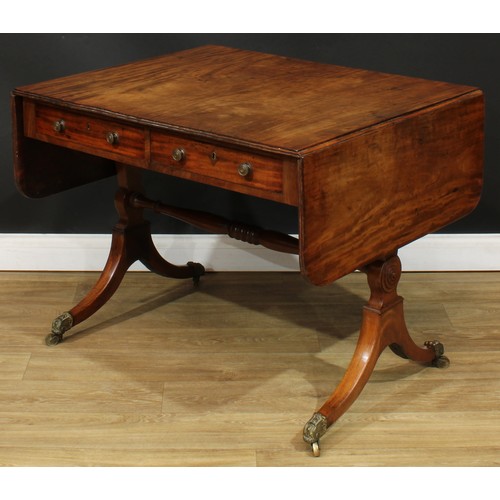 1767 - A Regency mahogany sofa table, rounded rectangular top with reeded edge and fall leaves above a pair... 