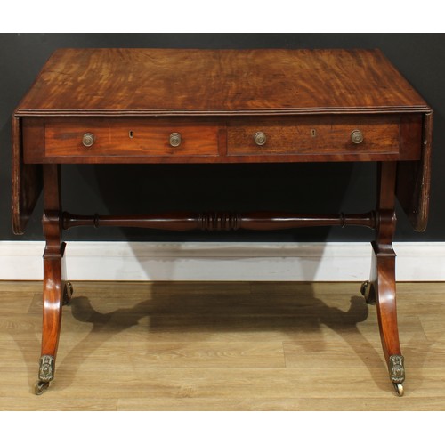 1767 - A Regency mahogany sofa table, rounded rectangular top with reeded edge and fall leaves above a pair... 