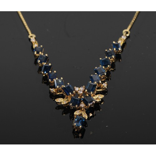 410 - A 14ct gold and sapphire necklace, accented with diamonds, marked 585, boxed with soft cloth pouch