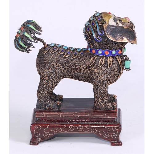 88 - A Chinese silver and enamel model of a temple lion, profusely applied with filigree scrolls, hardwoo... 