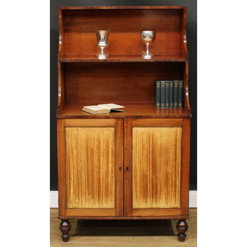 1770 - A Regency mahogany waterfall bookcase cabinet, shaped superstructure above a pair of doors enclosing... 