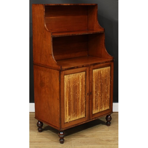 1770 - A Regency mahogany waterfall bookcase cabinet, shaped superstructure above a pair of doors enclosing... 