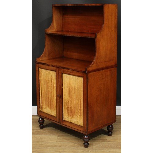 1770 - A Regency mahogany waterfall bookcase cabinet, shaped superstructure above a pair of doors enclosing... 