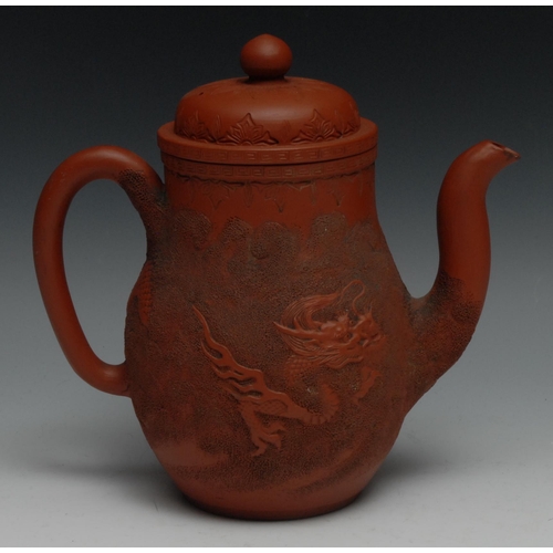 992 - A Chinese Yixing ovoid wine pot, in relief with ferocious dragons, 22cm high, impressed seal mark