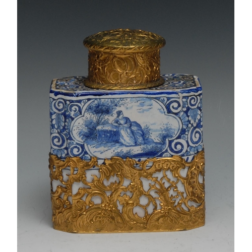 521 - A Dutch Delft canted rectangular tea caddy, painted in tones of blue with figures and landscape vign... 