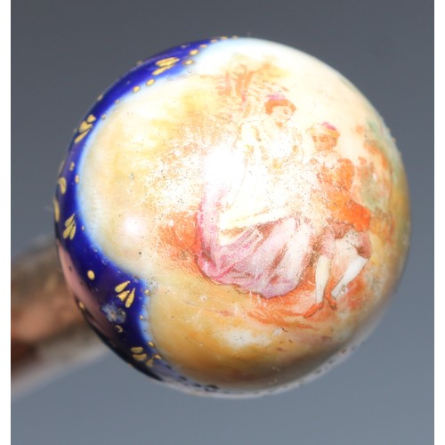 1337 - A Continental porcelain mounted walking stick, globular pommel decorated with a putto scattering flo... 