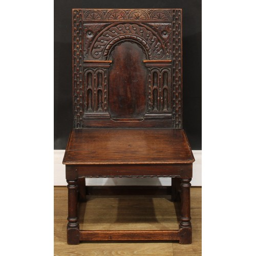 1402 - A 17th century style oak child’s wainscot side chair, the back carved with a frieze of lunettes abov... 