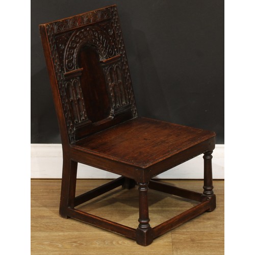 1402 - A 17th century style oak child’s wainscot side chair, the back carved with a frieze of lunettes abov... 