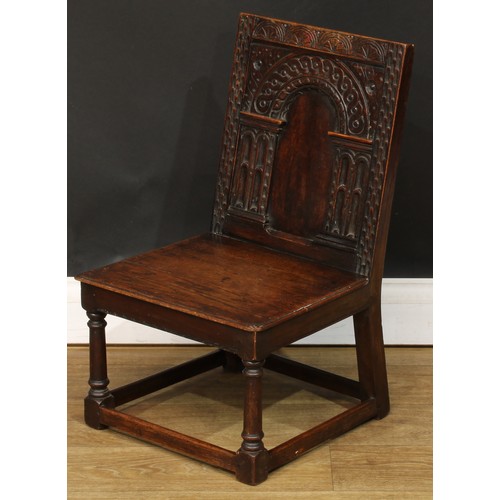 1402 - A 17th century style oak child’s wainscot side chair, the back carved with a frieze of lunettes abov... 