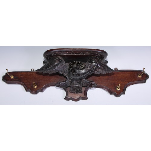 1835 - A softwood and mahogany wall mounted coat rack, carved in the Black Forest taste with an eagle, 81.5... 