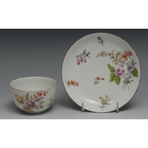 543 - A Chelsea tea bowl and saucer,  painted with Meissen style flowers under a brown line rim, red ancho... 