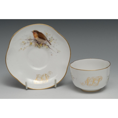 648 - A Royal Worcester teacup and saucer,  painted with birds perched on blossoming branches, gilt initia... 