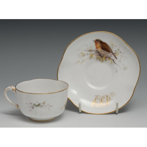 648 - A Royal Worcester teacup and saucer,  painted with birds perched on blossoming branches, gilt initia... 