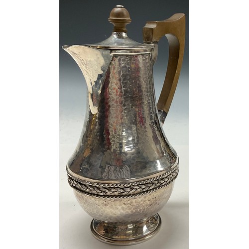 112 - A E Jones - an Arts and Crafts silver water jug, planished overall, applied rope twist girdle, 20.5c... 