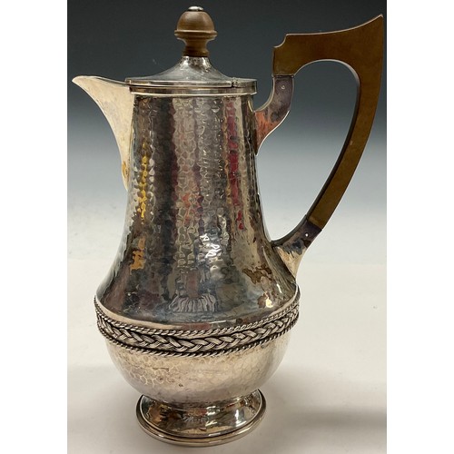 112 - A E Jones - an Arts and Crafts silver water jug, planished overall, applied rope twist girdle, 20.5c... 