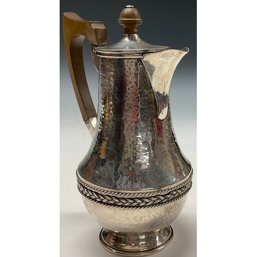 112 - A E Jones - an Arts and Crafts silver water jug, planished overall, applied rope twist girdle, 20.5c... 