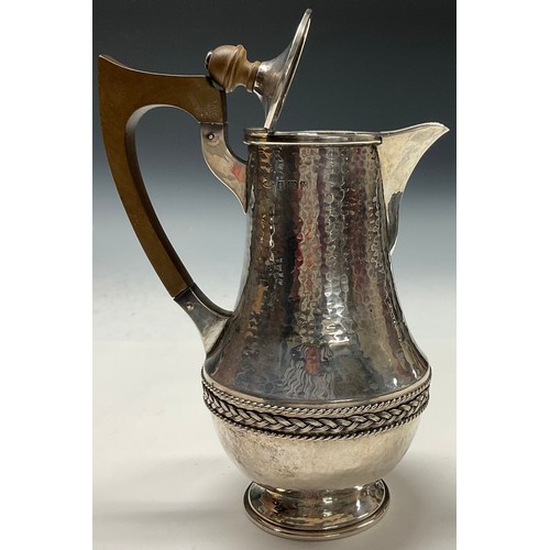 112 - A E Jones - an Arts and Crafts silver water jug, planished overall, applied rope twist girdle, 20.5c... 