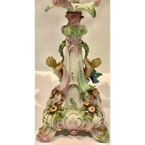 77 - A Sitzendorf porcelain four light two section candelabrum, the column with seated putto, encrusted w... 