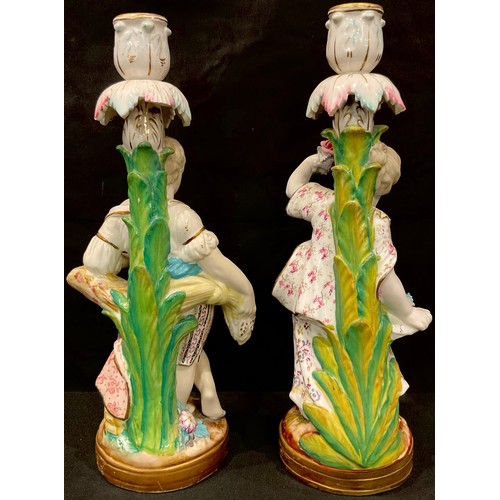 129 - A pair of 19th century Minton figural candlesticks, modelled as a young boy and girl, he stands over... 