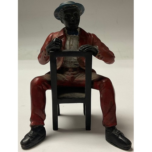 152 - A cold painted bronze, Mississippi Dandy, seated on a chair, 12cm high