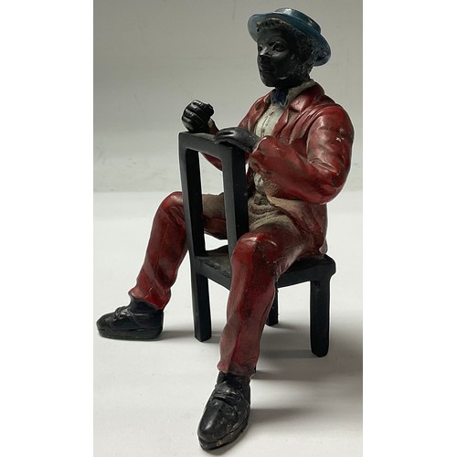 152 - A cold painted bronze, Mississippi Dandy, seated on a chair, 12cm high