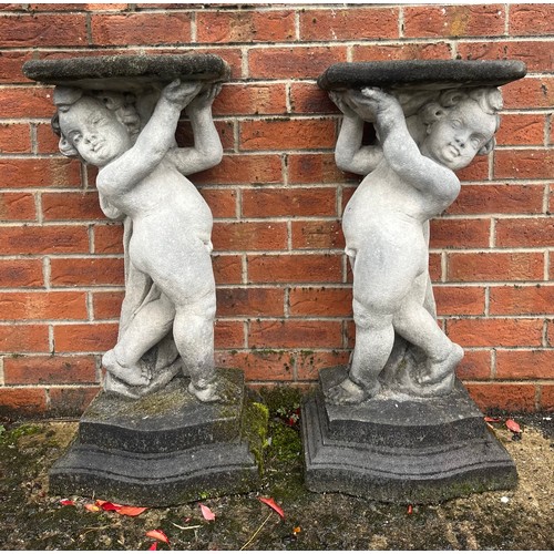 3172 - A pair of garden pedestals, each modelled as a putto supporting a plateau, each 79cm high

**Please ... 