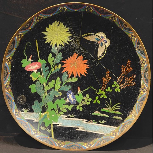 213 - A Japanese cloisonné charger, enamelled with butterfly, spider's web and flowers over a stream, 30.5... 